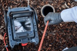 Technician inspecting data cable with waterproof camera in storage facility.