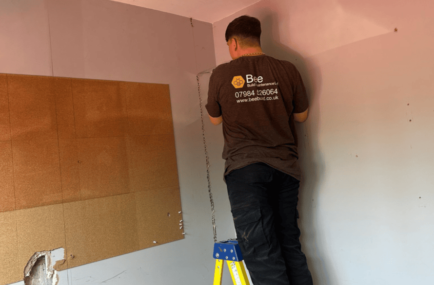 Bee Maintenance Employee drilling internal wall