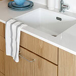 Modern kitchen sink with wooden cabinets and blue bowls, clean and stylish.