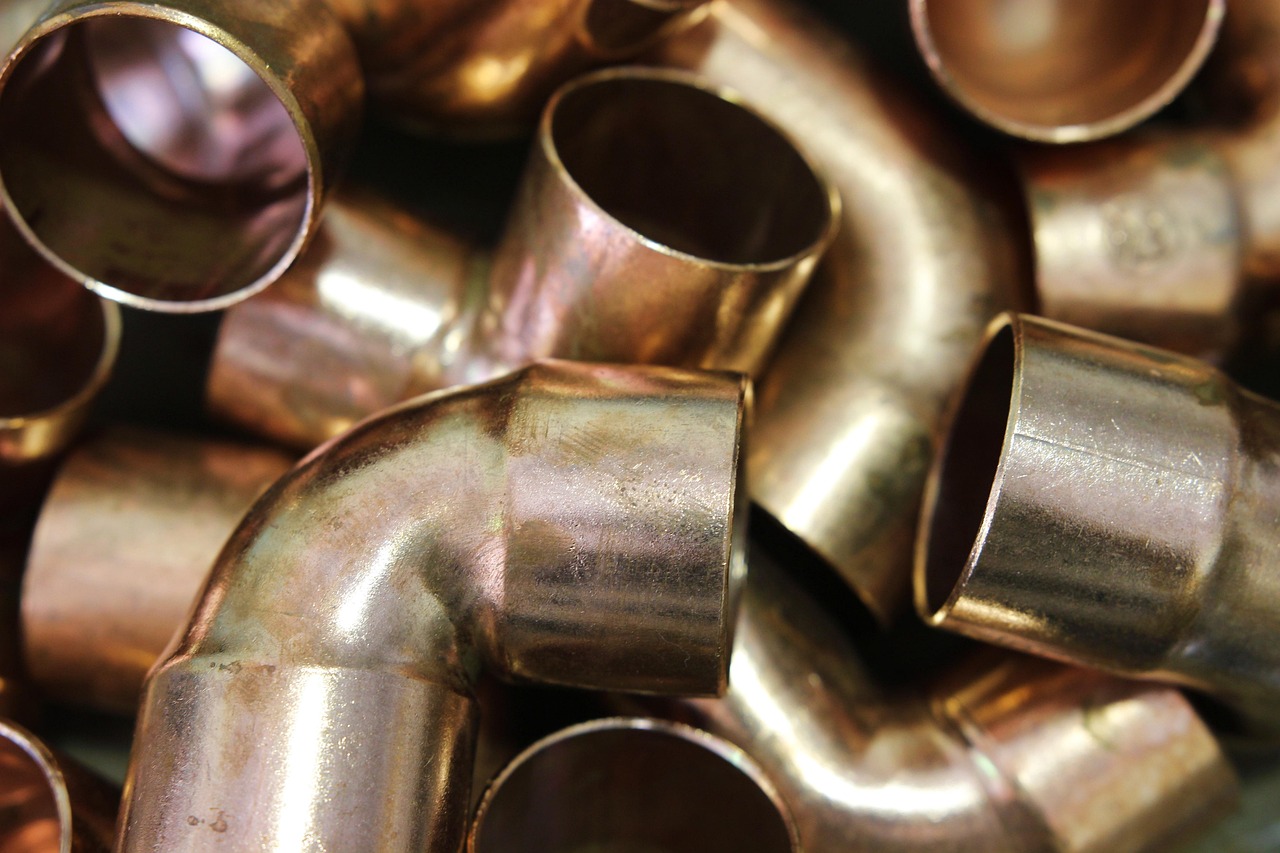Pile of copper plumbing elbow and straight fittings