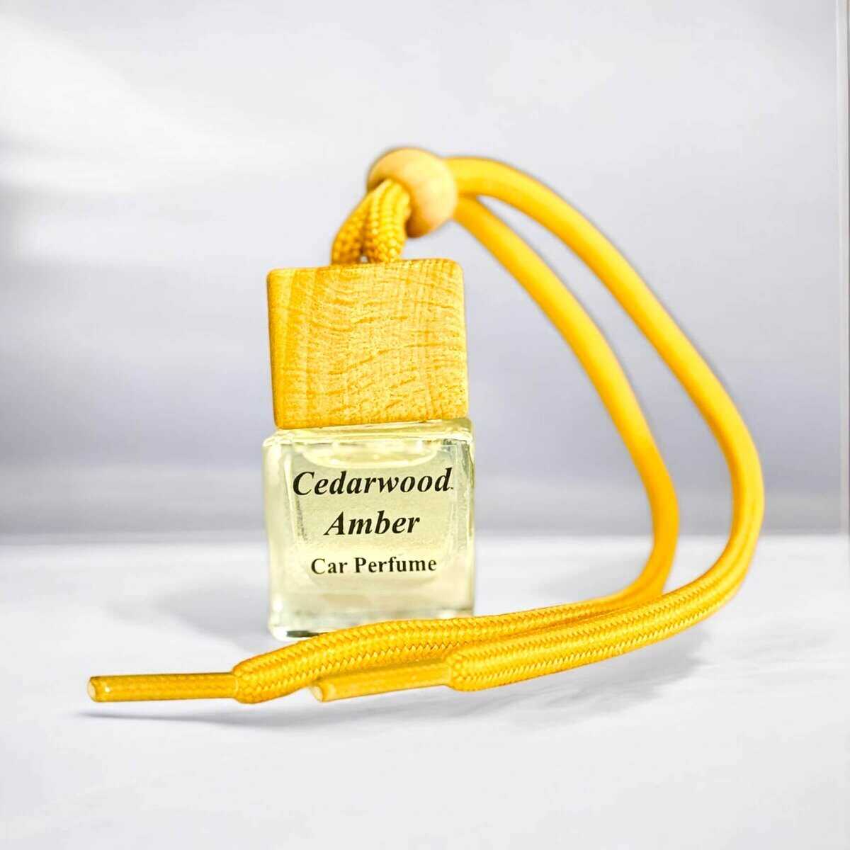 Cedarwood Amber car diffuser with yellow cord and wooden cap, ideal for freshening up your vehicle.
