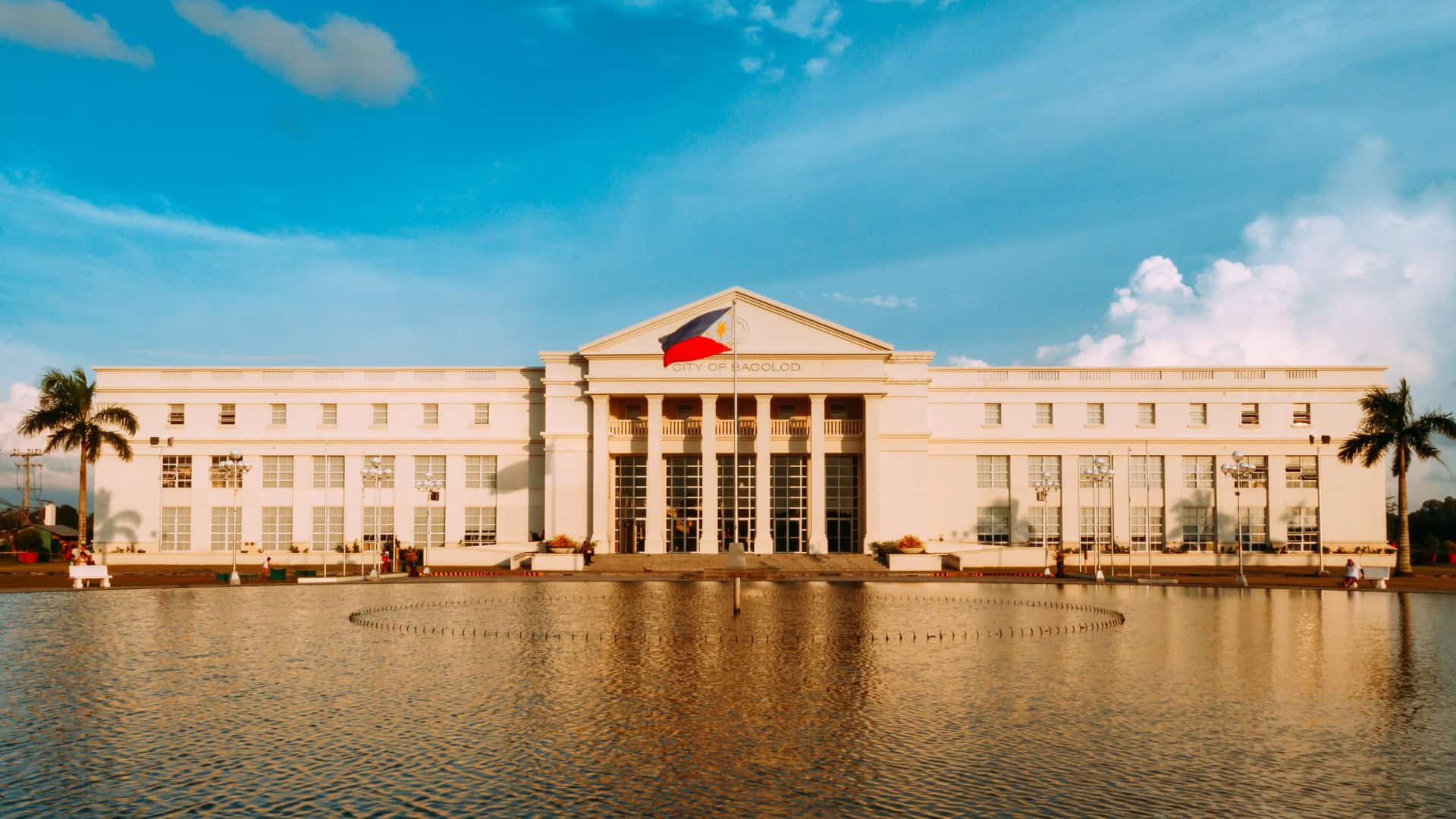 Large white civic building with reflecting pool (city landmark)
