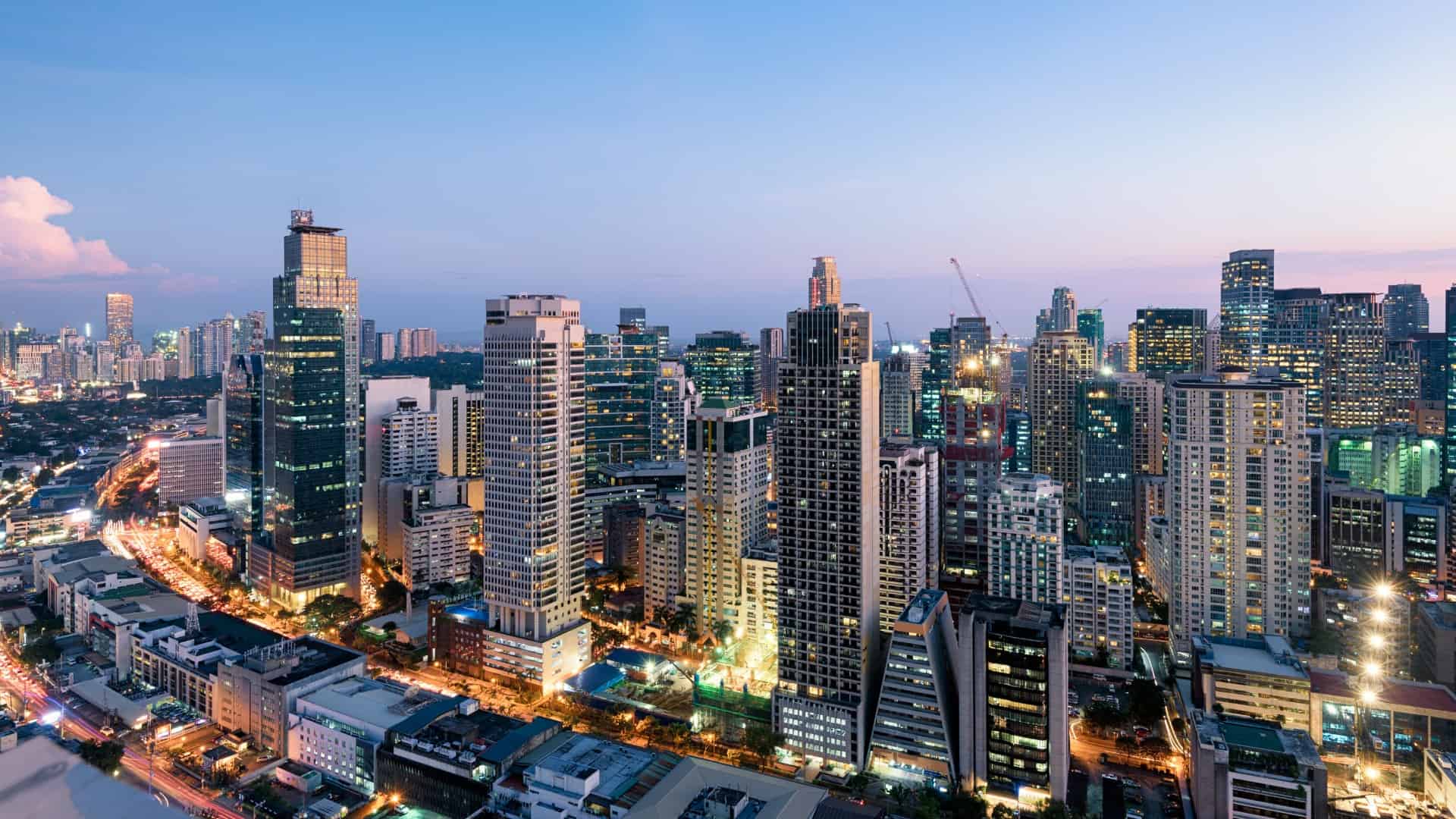Dense Philippine urban skyline with high-rise buildings at dusk