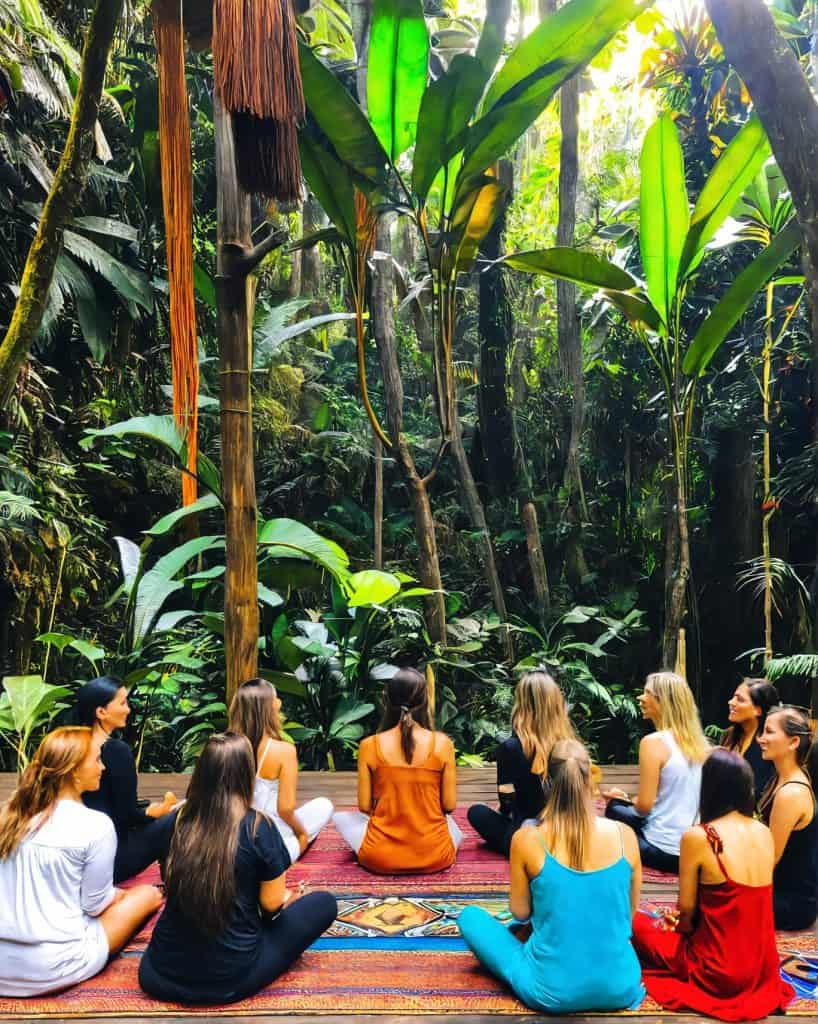 Yoga retreat in vibrant jungle surrounded by tropical greenery.