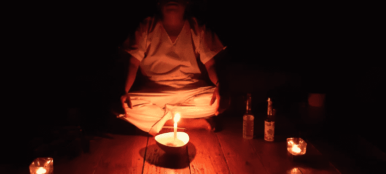Meditation session in dim candlelight at Naturalia Retreat Center.