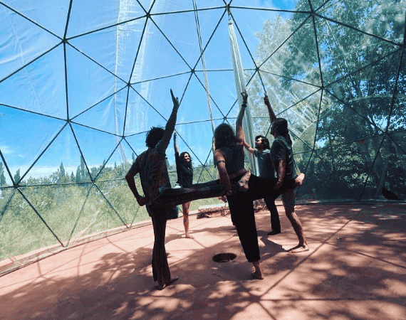 Yoga session inside La Mezquita dome with lush greenery outside.