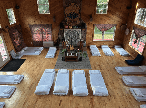 A peaceful indoor setting with mats arranged for a spiritual Ayahuasca ceremony in a rustic wooden r.