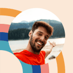 Happy man enjoying nature at a retreat location, smiling and pointing towards scenic mountains.