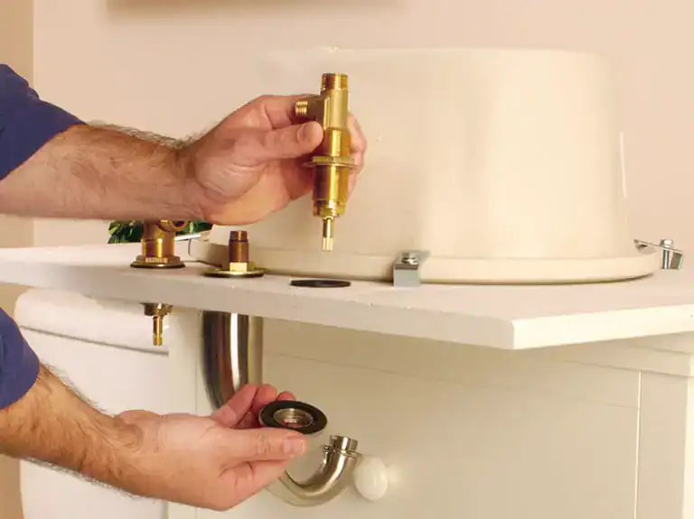 Plumber installing a faucet component, showcasing precision in plumbing fixtures and installation services.