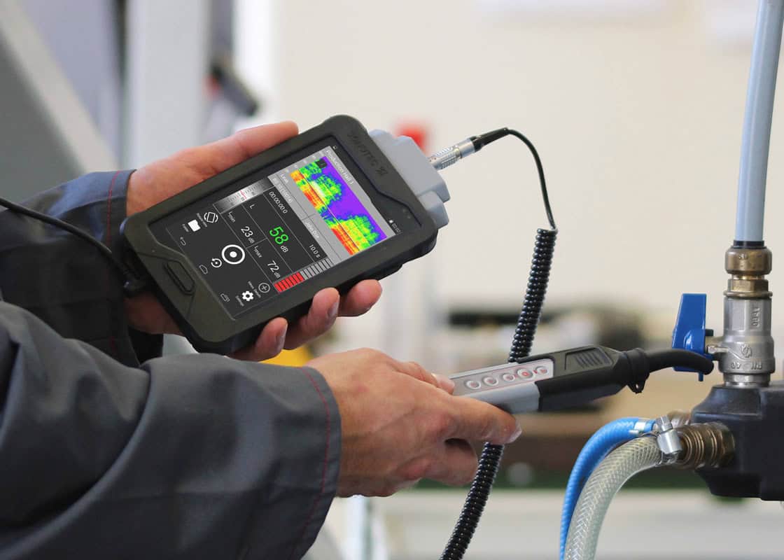 Technician using advanced leak detection equipment to identify plumbing issues, showcasing a digital display with measurements and analysis tools.