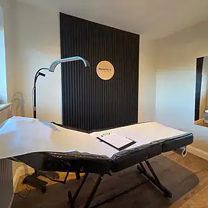 Relaxing massage room featuring a professional treatment table and contemporary black wall decor for.