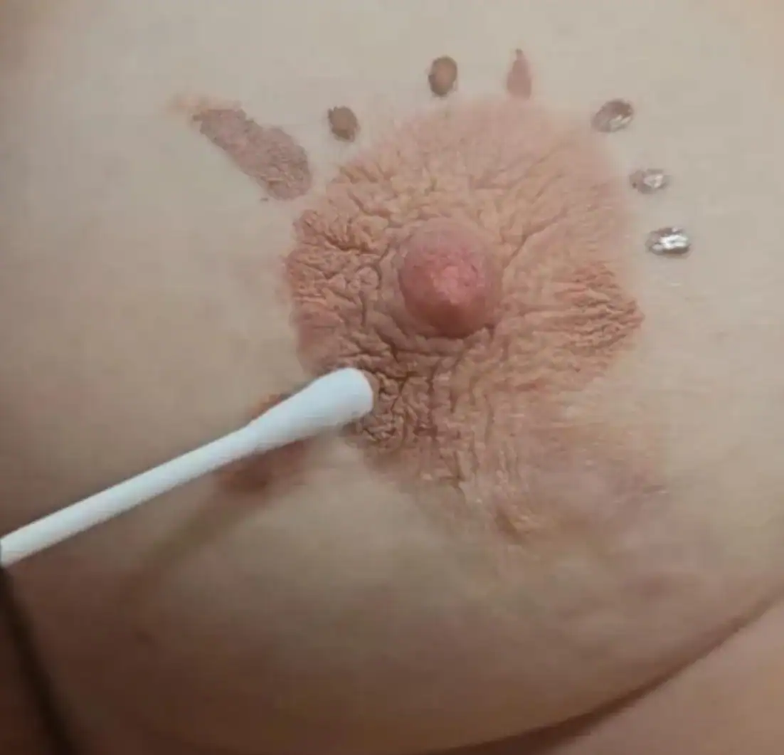 Creative belly art featuring a bear face design with textured details and decorative rhinestones.