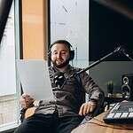 Portrait of happy young man working as radio host at radio station.