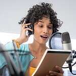 A Beautiful Young Black Woman With Curly Hair Reading Her Notes Script