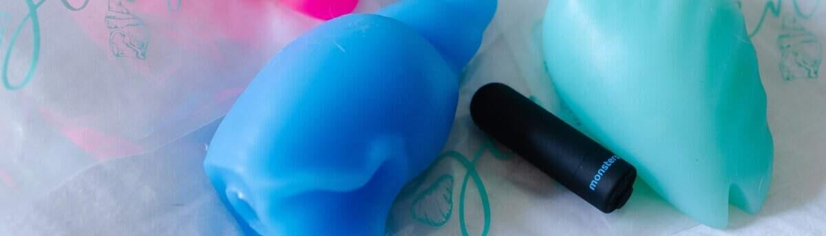 imagem de modelos de sex toys expostos sobre uma cama representando vibrador online