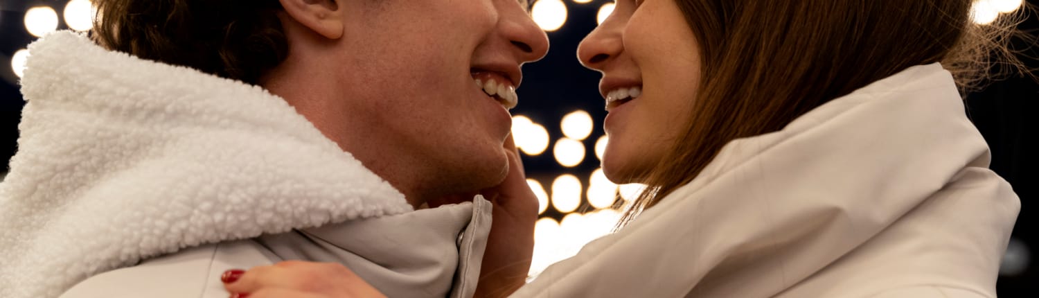 uma mulher e um homem olhando um para o outro sorrindo com casacos brancos