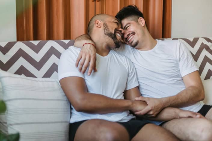 Broders dois homen sentado no sofa se abraçando e rindo
