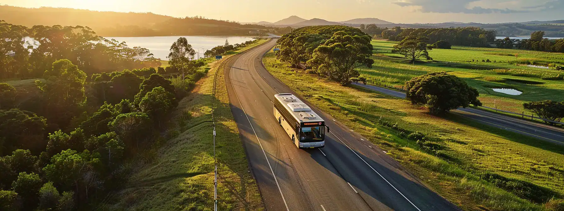 a sleek bus glides along a scenic coastal highway, with the vibrant green countryside of gympie in the background, evoking a sense of convenience and adventure for travelers heading to brisbane airport.