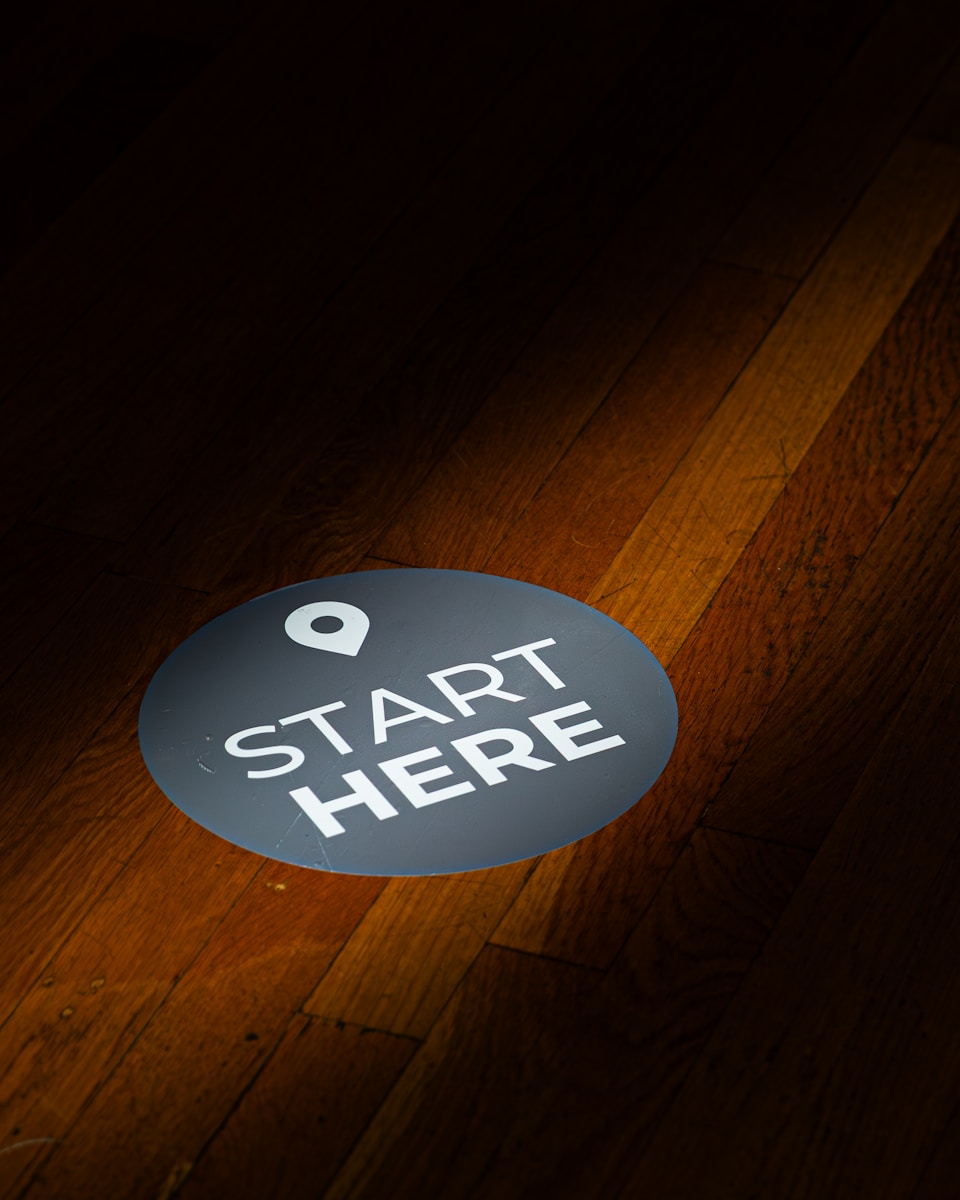 A round floor sticker with "start here" text.