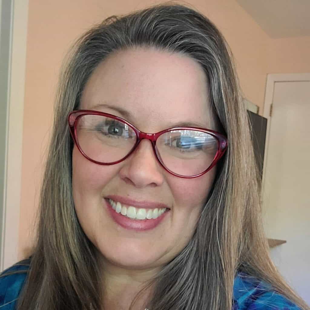 Portrait of a woman with glasses smiling, promoting The BoatHouse Girls Podcast content.