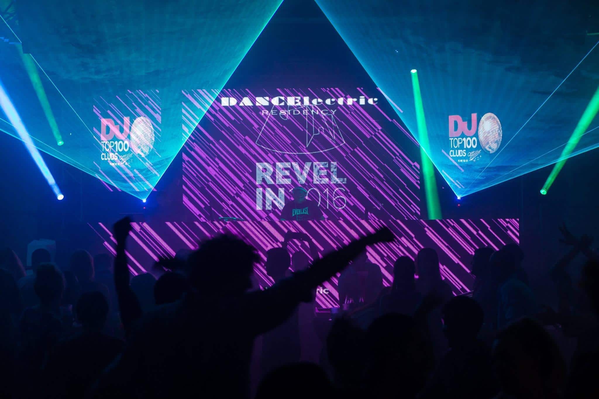 A DJ performing at Revelin Fortress in Dubrovnik, with vibrant lights and an energetic crowd inside the historic 16th-century venue.
