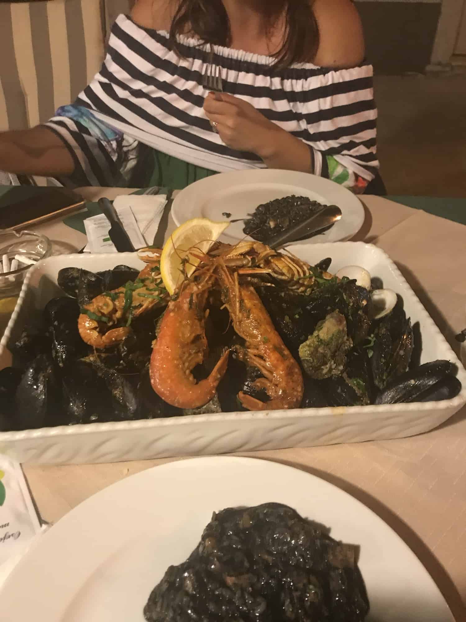 Black risotto and Buzara-shrimps and shells in tomato sauce a great Local Food dishes