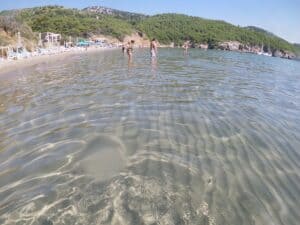 Tour guests walking on the sandy shore of Šunj