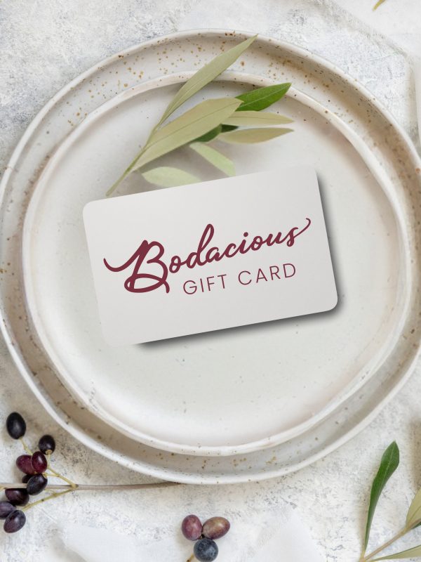 Elegant Bodacious Shops gift card on ceramic plate with greenery and berries, perfect for gift-giving, stylish floral design, and versatile for various occasions.