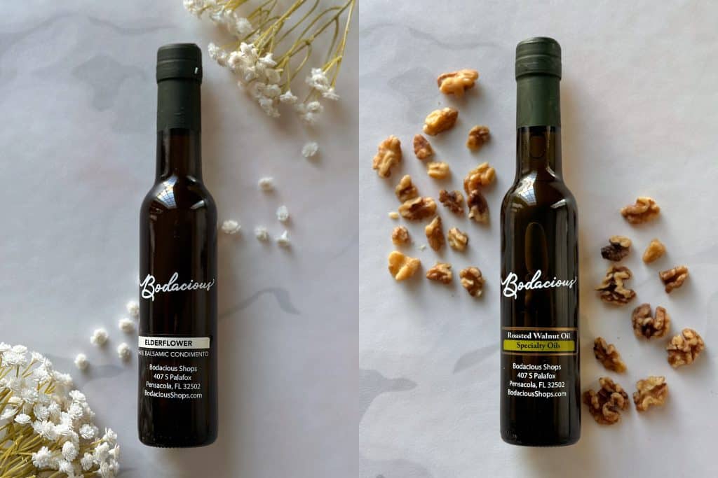 Elderflower balsamic condiment bottle with dried white flowers in background, natural aesthetic, premium quality ingredients, Bodacious Shops, Florida, specialty food products.