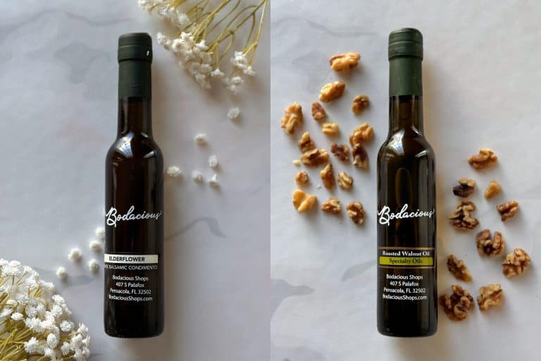 Elderflower balsamic condiment bottle with dried white flowers in background, natural aesthetic, premium quality ingredients, Bodacious Shops, Florida, specialty food products.