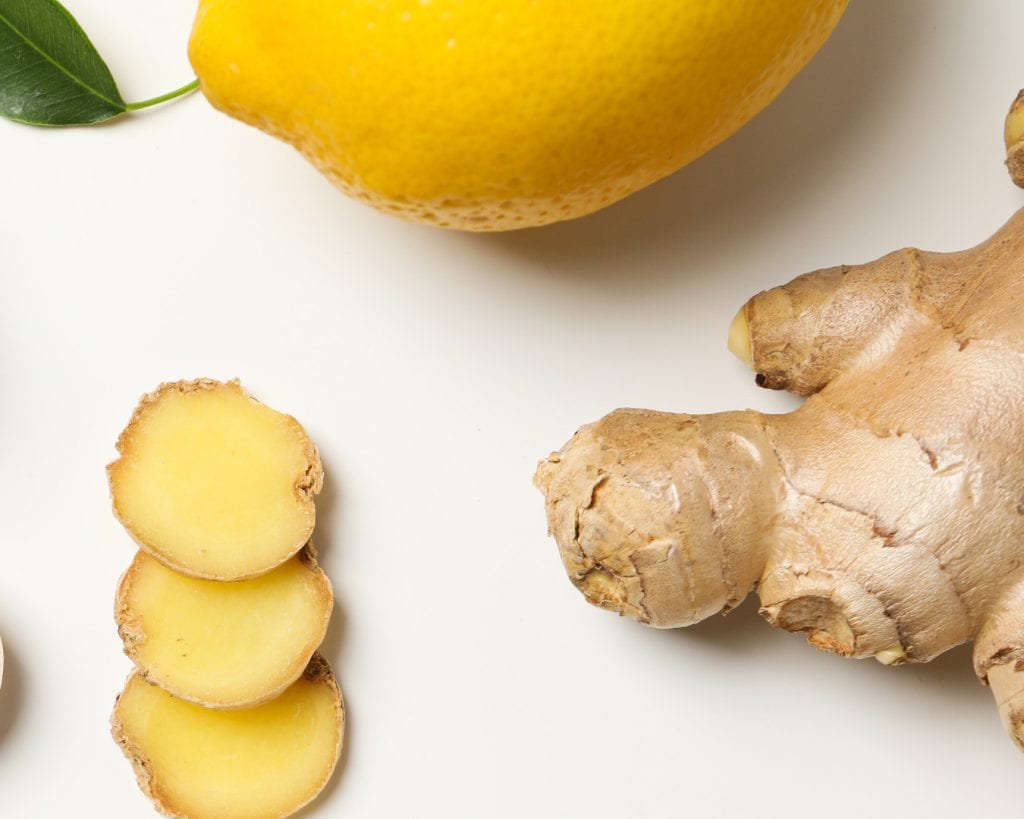 Fresh ginger root and a yellow pear on a white background; healthy organic produce, natural ingredients, ginger for cooking and wellness.