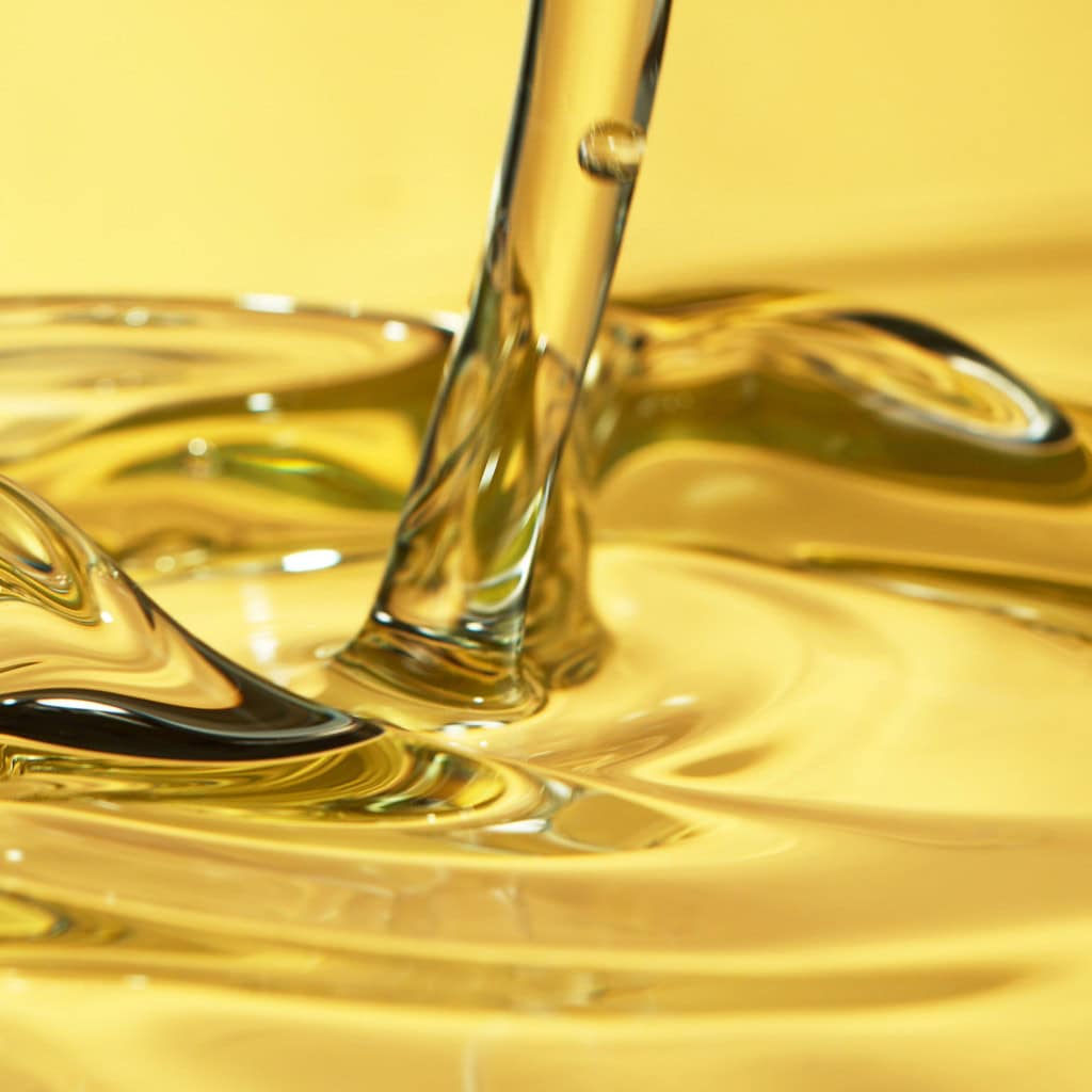 Golden liquid being poured, close-up shot of smooth caramel or honey flowing, high-quality image of glossy, viscous substance for food or product display.