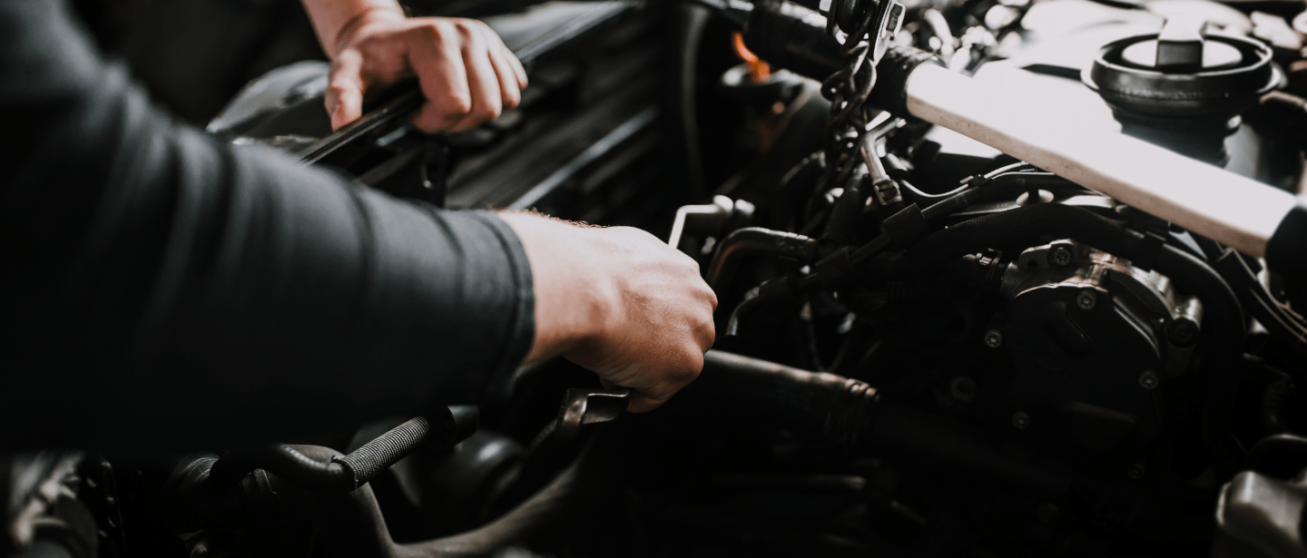Engine repair technician working on a vehicle engine at Boise Muffler Auto Repair.
