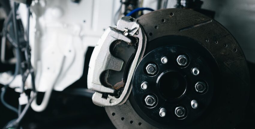 Close-up of a car brake disc and caliper at Boise Muffler Auto Repair.
