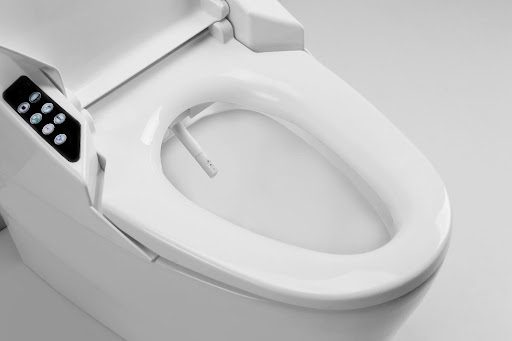 A white bidet toilet seat, reminiscent of a sleek insider tip from May 2022, features an attached control panel and visible nozzle, set against a plain background—a testament to Bonfe's commitment to modern bathroom innovations.