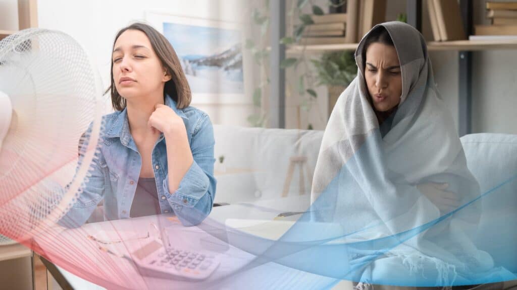 Two women sit indoors, one cooling herself with a fan while the other wraps up in a blanket, highlighting uneven temperature and hot and cold spots in home heating. A visual overlay shows the contrasting hot and cold air effects.