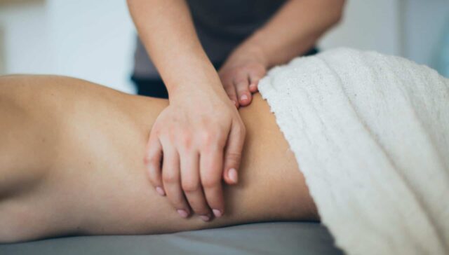 Massage therapist treating soft tissue injury to relieve tension and promote healing.