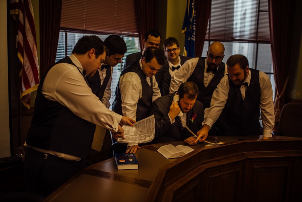 A group of men signing a document in a courtroom during a wedding at the Wisconsin Capital.