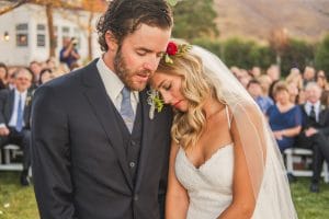 A Littleton Wedding Photographer captures the heartfelt embrace of a bride and groom at their ceremony.