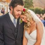 A bride and groom hugging during their wedding ceremony.