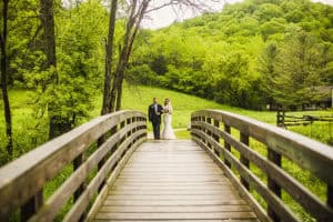 A Norskedalen wedding party on a wooden bridge.
