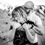 A man and woman hugging in the desert.