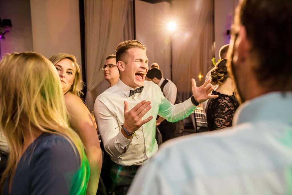 A man is dancing on the dance floor at a wedding.
