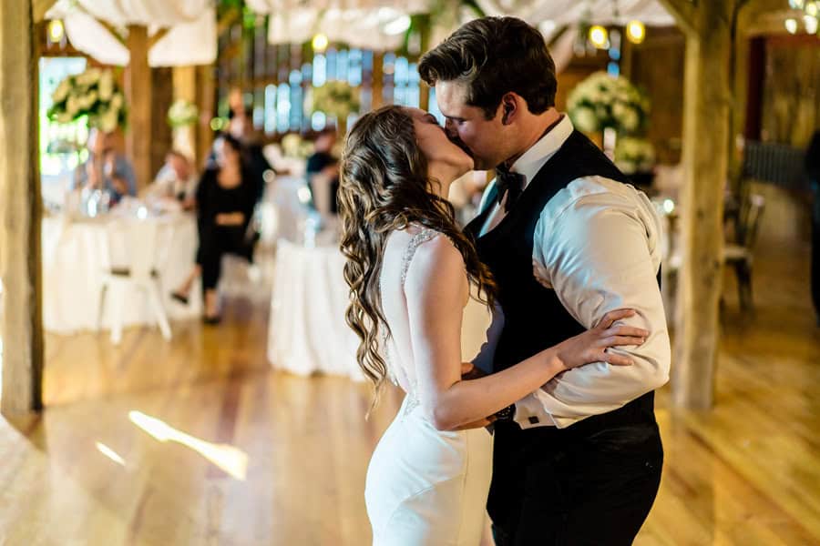 A bride and groom kiss during their first dance.
