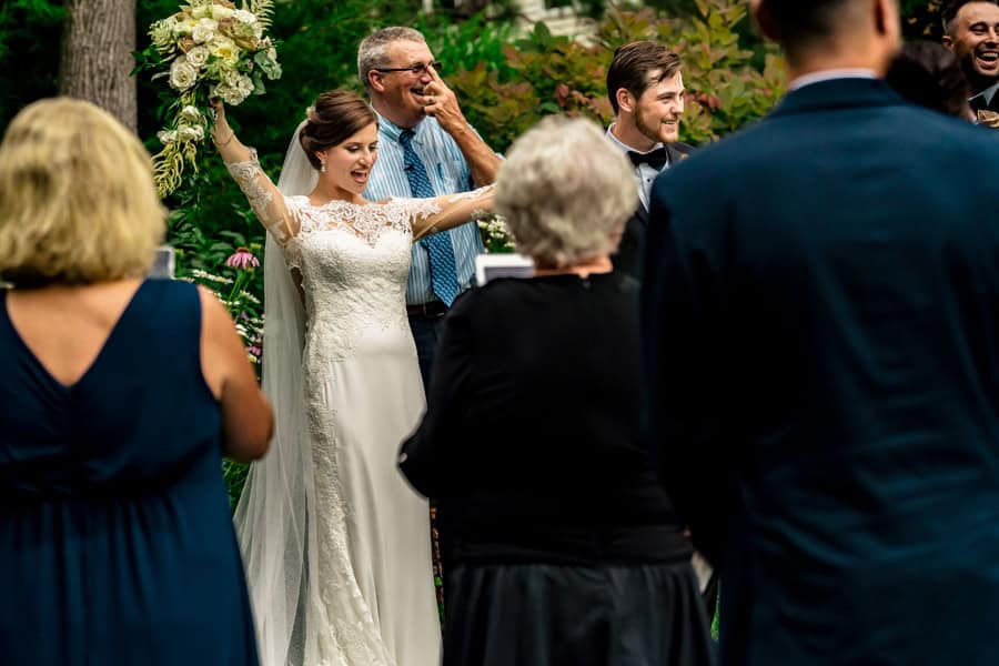 A bride and groom are celebrating their wedding in a garden.