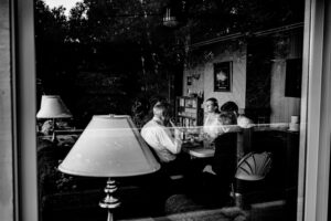 A black and white photo of a group of people sitting around a table.