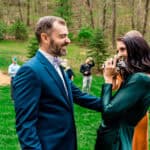 A bride and groom share a love-filled kiss during their backyard wedding ceremony.