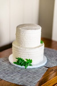A white cake sitting on a wooden table.
