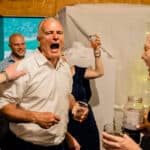 A man shouting at a group of people at Courtney and James' Love-Filled Backyard Trempleau Wedding.