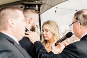 A bride and groom talking to each other in front of a microphone.